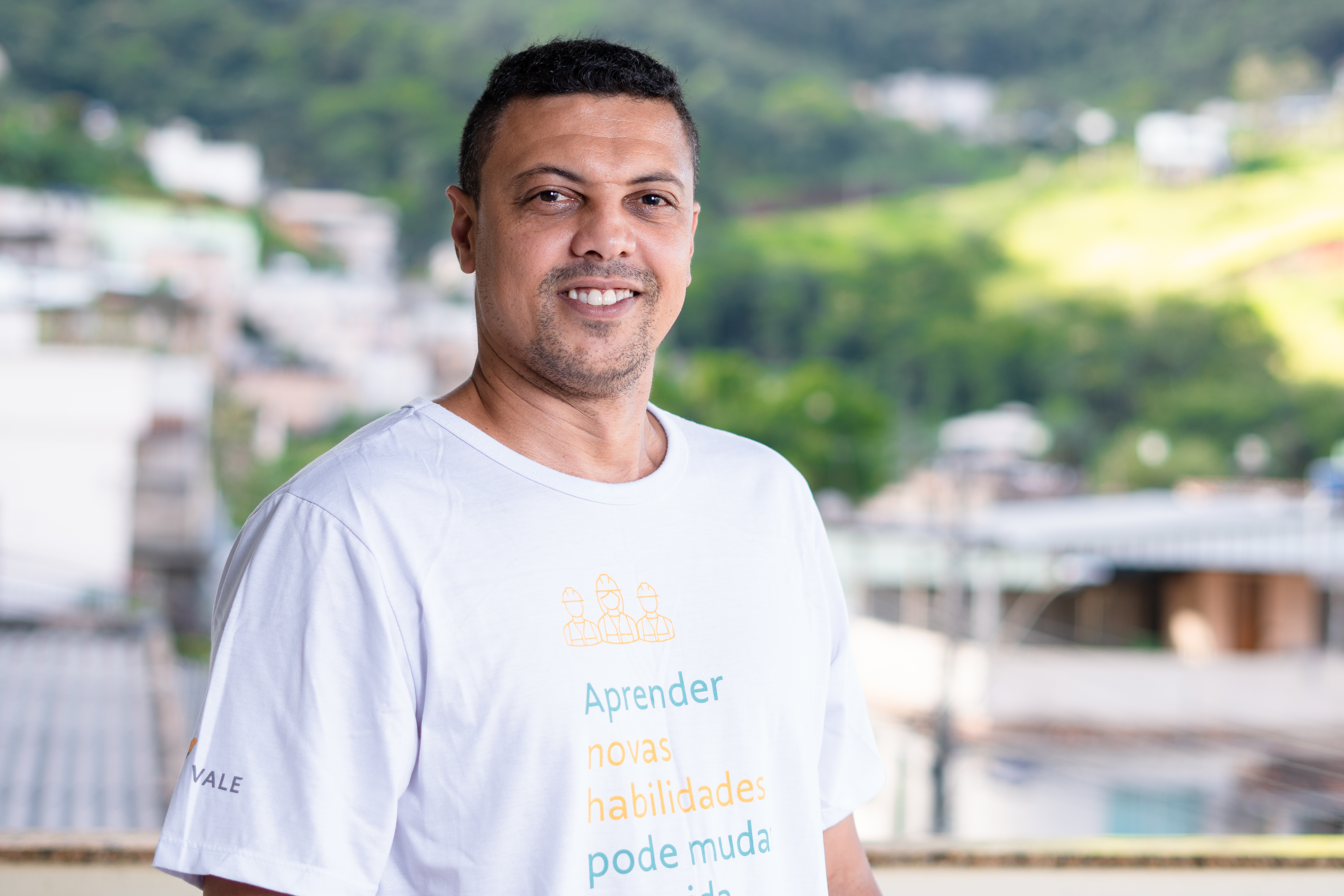 Imagem de Edimar Donizete Elizeu da Silva Pereira, aluno do curso de Eletricista Montador SENAI Itabirito (2022), sorrindo. Ele veste a camiseta do projeto. 
