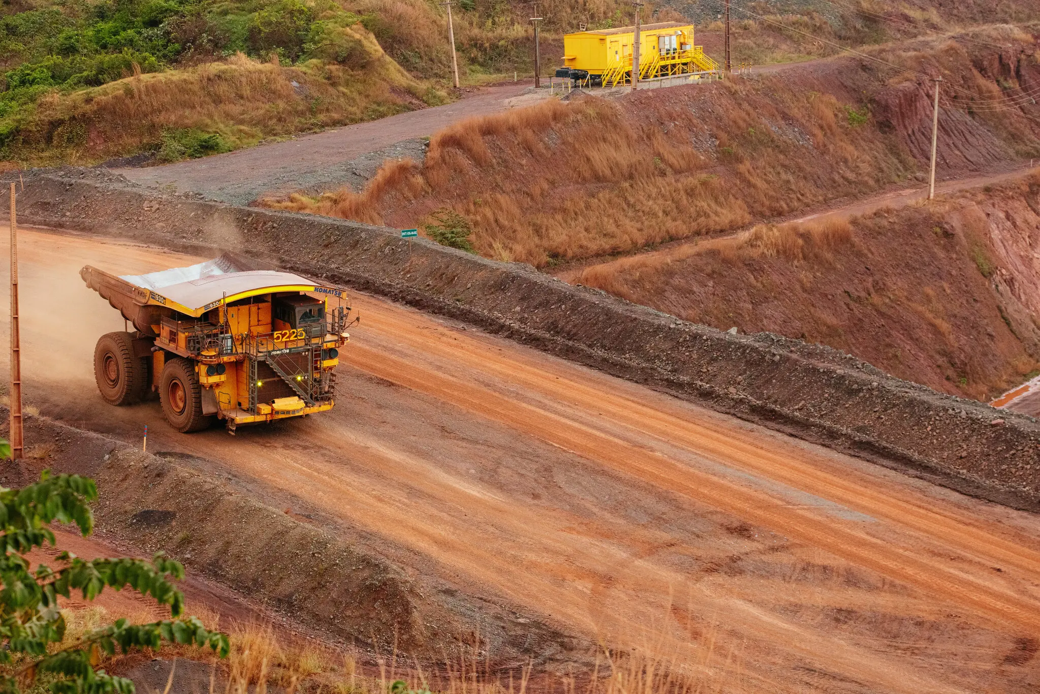 Yellow mining truck on a dusty red dirt road