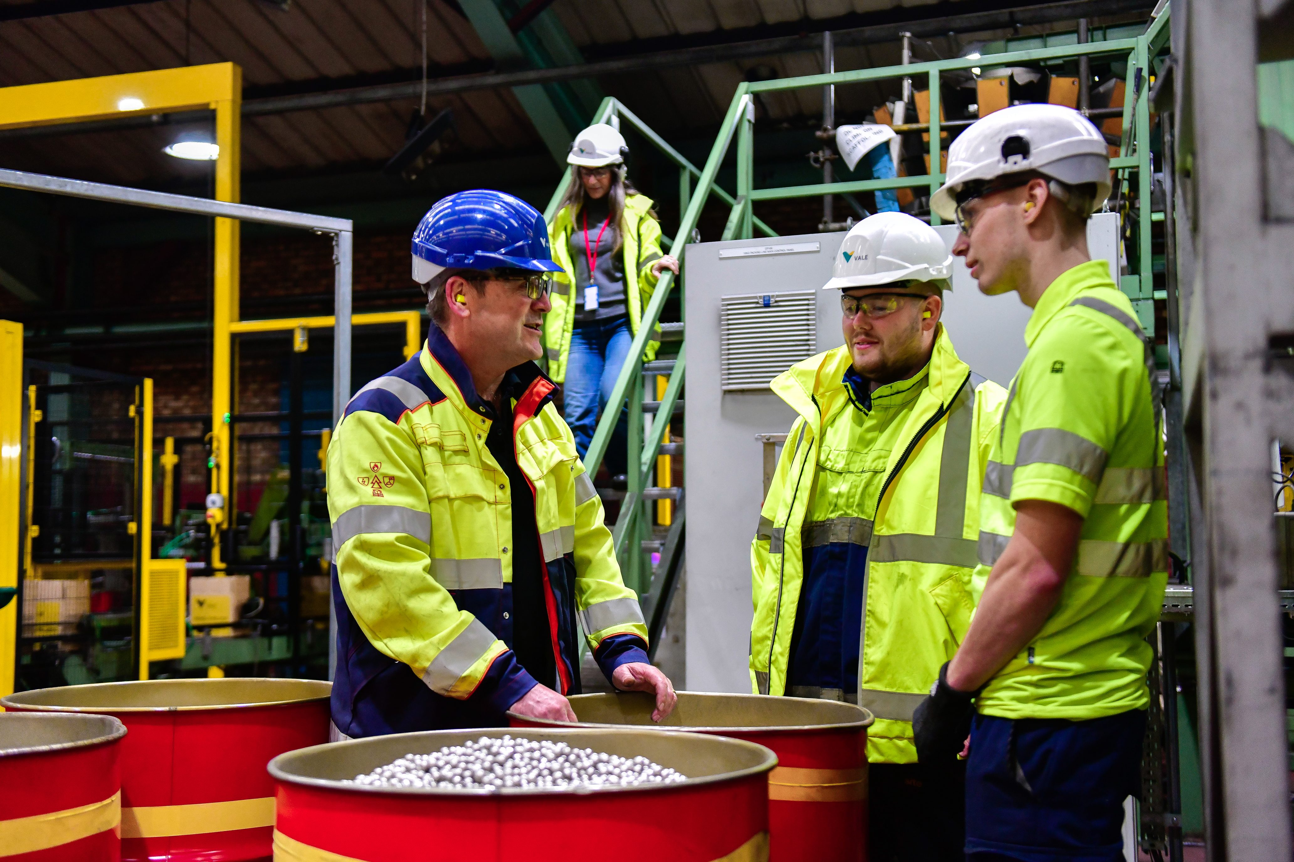 Three employee in an operation area. All of them wears protection equipaments