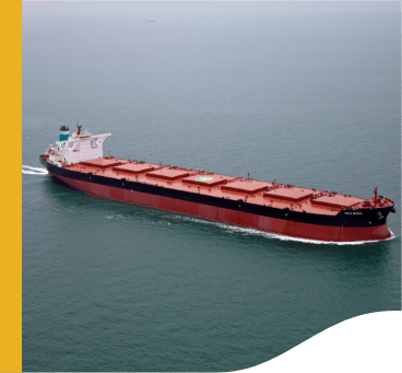 Image of a large cargo ship. It is red and has a black stripe, and is sailing on the high seas.