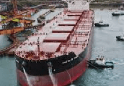 Aerial photo of a ship with several boats alongside it