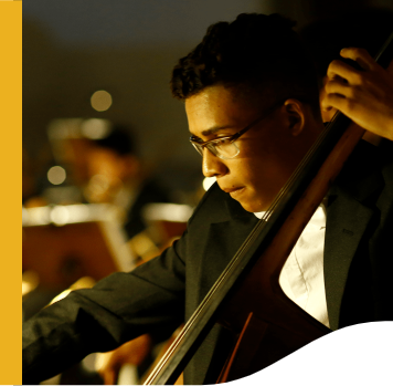 Young man, wearing glasses, playing a musical instrument. He's wearing formal clothes.