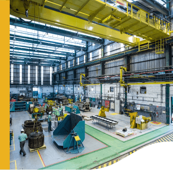 Image of a shed with several machines. You can see some Vale employees, all wearing helmets.