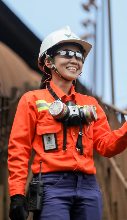 Seorang wanita mengenakan seragam Vale, kacamata, helm, dan perlengkapan pelindung lainnya saat ia berpose sambil tersenyum untuk difoto.