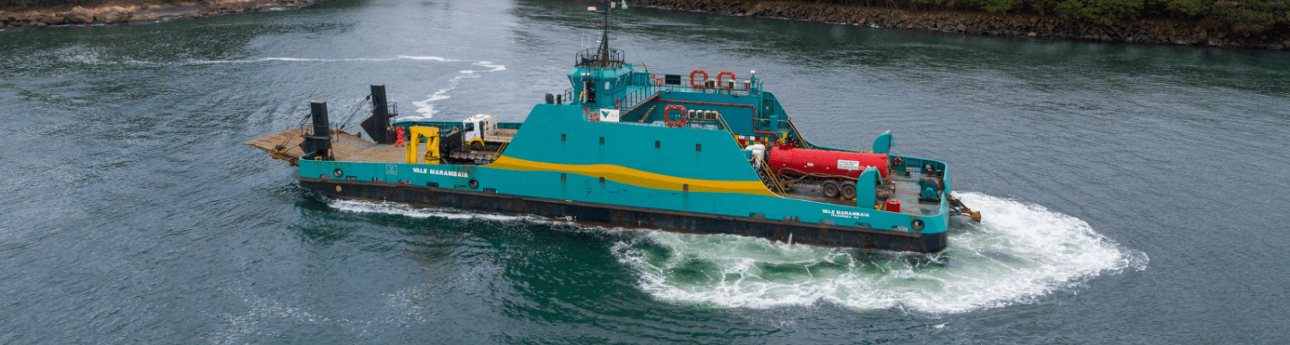 Green and yellow operational boat floating on a big lake.