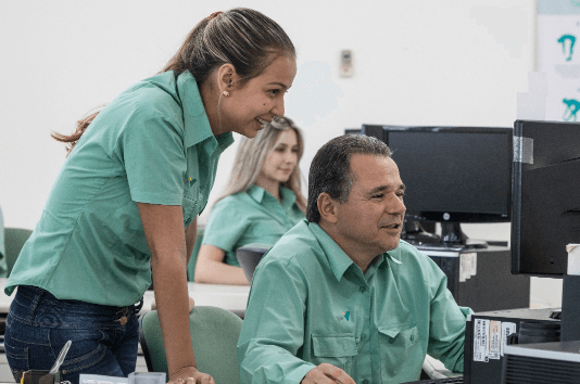 Duas pessoa sendo um homem e uma mulher, aparentemente trabalhando com uma outra de fundo concentrada