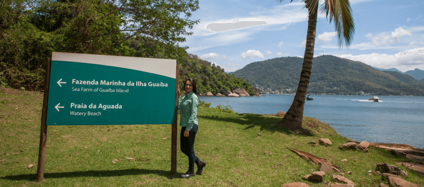 Foto de um mar e parte de concreto com grade e uma boia salva-vidas pendurada