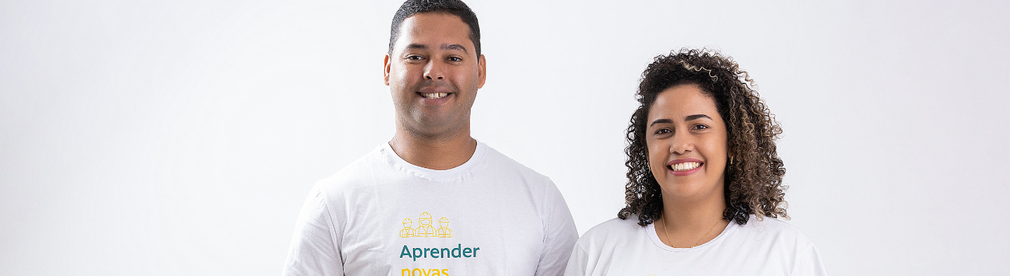 Imagem de um homem e uma mulher sorrindo. Ambos usam a camiseta do Programa de Preparação para o Mercado de Trabalho