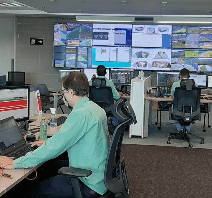 People in an office monitoring Vale dams using computers