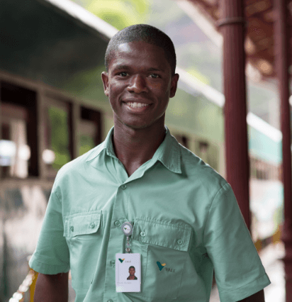 Empregado  Vale sorri para foto. Ele é um homem negro.