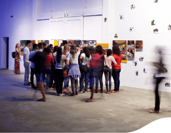 Several people are standing around looking at paintings from an exhibition.