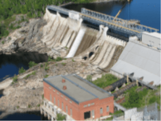 Foto de uma pequena central hidrelétrica de High Falls II. Uma estrutura com tijolos e janelas em uma ponte e embaixo um rio passando.
