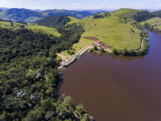 Photo of Mello SHP from above, one part of the photo with vegetation, mountains and trees and the other with water