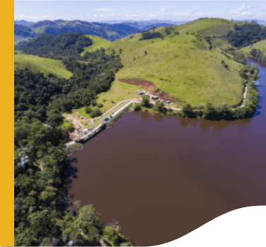 Photo of Mello SHP from above, one part of the photo with vegetation, mountains and trees and the other with water