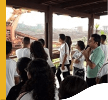 A big group of young people, all in school uniforms, observe Vale external operation, while a company employee accompanies them