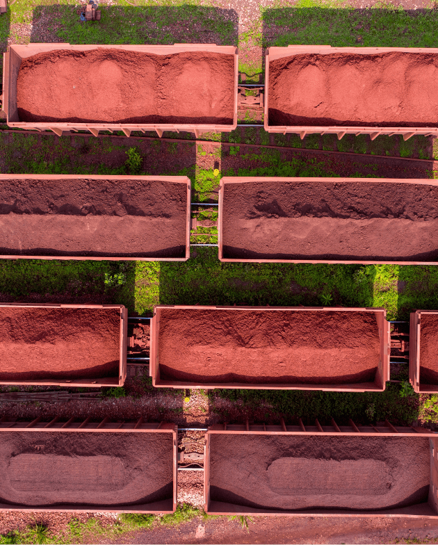 Foto de várias caçambas enfileiradas com minério e terra dentro