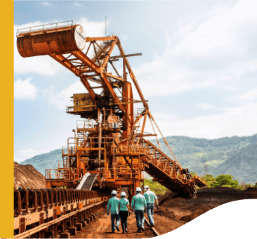 Some Vale employees walk through an outdoor operating area. There is a large iron structure on site