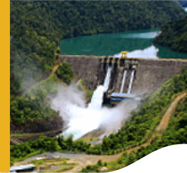 Photo of Wabageshik small hydropower plant with a concrete structure, rocks, vegetation, and moving water passing through the structures.