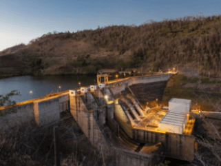 Photo of the Machadinho Hydropower Plant with a concrete structure and moving water passing through the structures.