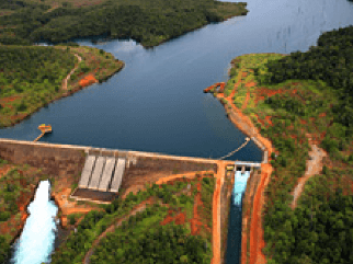 Foto da pequena central hidrelétrica Wabageshik com uma estrutura de concreto, pedras, vegetação e água em movimento passando pelas estruturas.